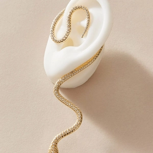 Elegant gold snake-shaped long drop earrings with white pavé zircons on ear model