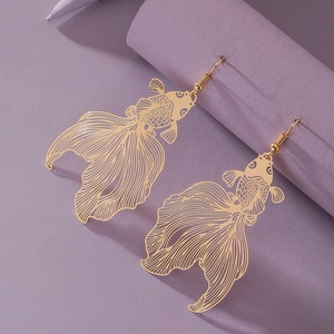 Elegant gold koi fish earrings in a hollow vintage design on a soft purple display