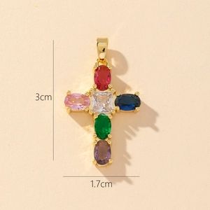 Macro detail of gold-plated cross pendant with colorful zircons and 3x1.7cm dimensions