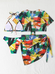 Dettaglio flat lay di un bikini a quattro pezzi con stampa tropicale, top in mesh e pareo
