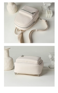 Detail of off-white lychee texture bag with silver zippers and protective metal feet