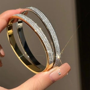 Detailed macro view of gold and silver brushed zircon bracelets with sparkling star effects