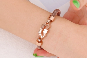 Close-up of rose gold mesh bracelet featuring a hollow MOM letter pendant on wrist