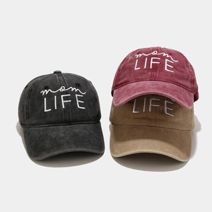 Close-up of three washed cotton baseball caps with mom LIFE embroidery in various colors
