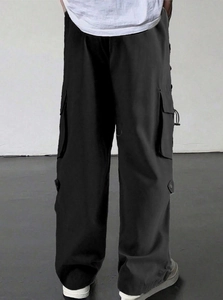 Detail shot of black tactical parachute pants with functional multi-pockets and straight leg cut