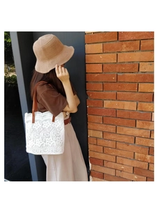 Vista dettagliata della borsa a spalla in pizzo bianco abbinata a un outfit casual giornaliero.