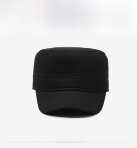 Detail of black military flat top hat showing twill fabric texture and silver metal logo