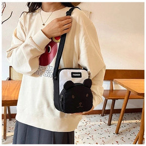 Detail of canvas crossbody bag with cartoon bear design and adjustable black strap