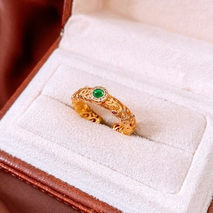 Detail of vintage 24k gold plated ring with floral engraving and green gemstone