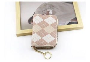 Detail of checkered canvas card holder with gold zipper and keychain on white background