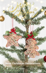 Detail of gingerbread-style felt star ornament hanging on a Christmas tree with bokeh lights