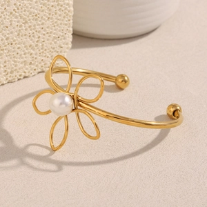 Detail of 18K gold-plated three-layer knotted wire bracelet with white pearl flower