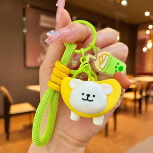 Close-up of a cute puppy keychain with green braided strap and boba tea charm