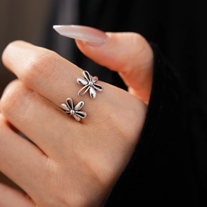 Detailed close-up of retro silver open ring with dual hollow flower daisy design