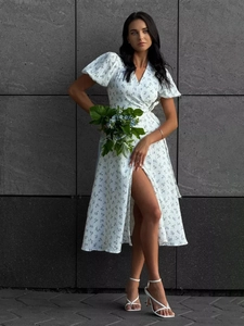 Detail of white floral puff sleeve dress with elegant side slit and wrap design