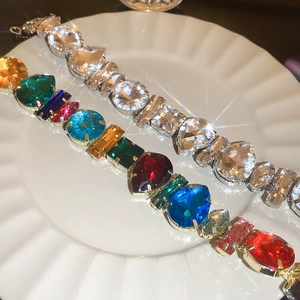Luxe crystal bracelets with colorful and clear gems on a white ceramic tray
