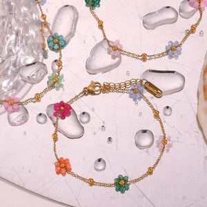 Close-up of a colorful beaded flower bracelet on a water-droplet glass surface