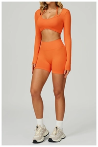 Full view of seamless orange yoga set featuring crop top and high waist shorts