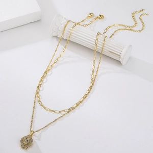 Detail of gold-plated double-layer chain featuring a sparkling leopard head pendant