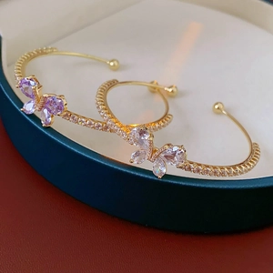 Détail du bracelet papillon doré serti de cristaux de zircone violets et blancs