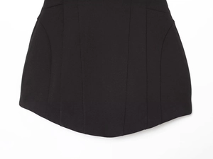 Vue détaillée de l'ourlet incurvé et des coutures de cette robe noire évasée