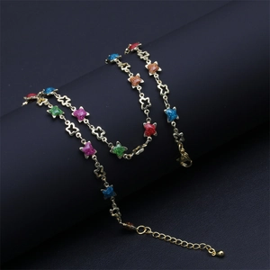 Detail of colorful glitter star charms on a gold adjustable necklace with lobster clasp