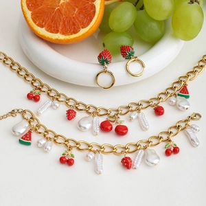 Detailed view of 18K gold-plated fruit charms and pearls on necklace and bracelet set