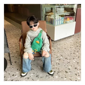 Zaino a tracolla per bambini verde brillante con becco d'anatra indossato da modella