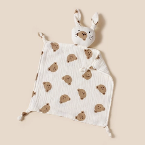 Détail d'un doudou en mousseline pour bébé avec motifs ours et tête de lapin en peluche