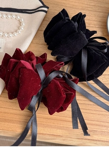 Detail of velvet bow hair clips in black and wine red with subtle sequins and ribbons