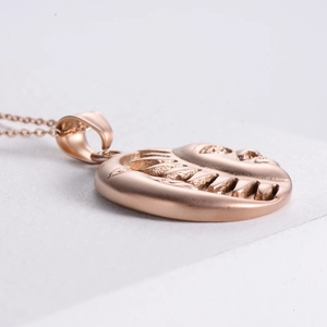 Macro side view of rose gold sun and moon constellation pendant with polished finish