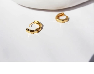 Macro detail of high-quality gold plated bamboo shaped hoop earrings for women