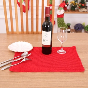 Festive red waffle weave Christmas placemat on a wooden table with holiday decorations
