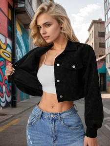 Detailed texture of black corduroy cropped jacket with metallic silver buttons