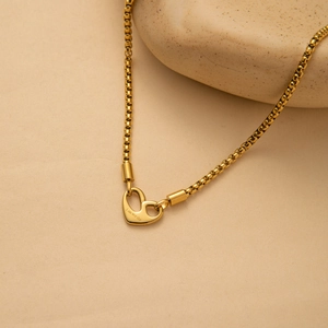 Detailed macro of golden heart pendant engraved with I AM WORTHY on a minimalist chain