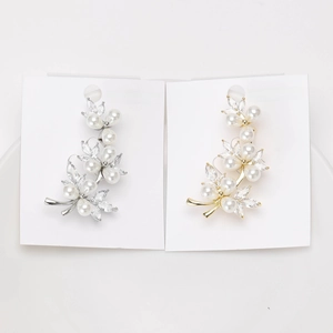 Detailed view of vine leaf ear cuffs with pearls and zircons in gold and silver finish