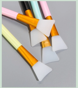 Detail of 5 silicone face mask brushes with colorful handles and gold ferrules