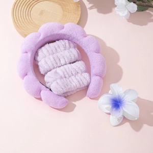 Detailed view of light purple sponge headband and matching plush wristbands for skincare