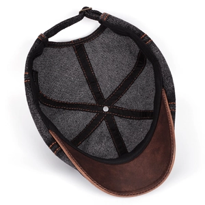 Inside view of vintage denim newsboy cap showing stitching details and leather brim