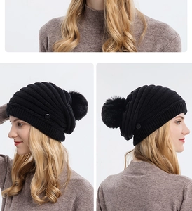 Détail du bonnet en maille noire avec pompon montrant la texture côtelée et le bouton