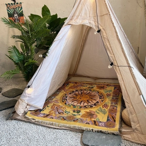 Bohemian sunflower camping blanket and outdoor mat under an ivory tent in nature