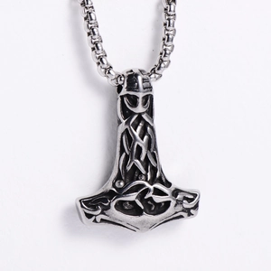Close-up of vintage stainless steel Mjolnir pendant with Celtic knotwork and square chain