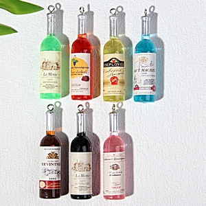 Set of colorful resin mini wine bottle pendants with metal loops in seven vibrant shades