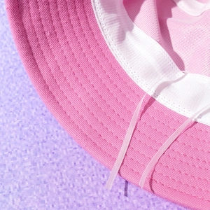 Detailed macro shot of the pink cotton bucket hat showing stitching and white sweatband