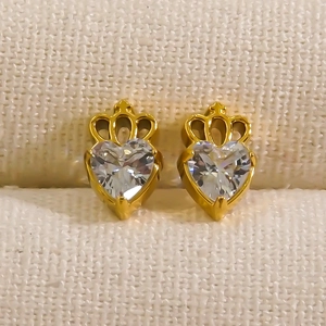 Golden crown heart stud earrings with sparkling cubic zirconia on cream jewelry box
