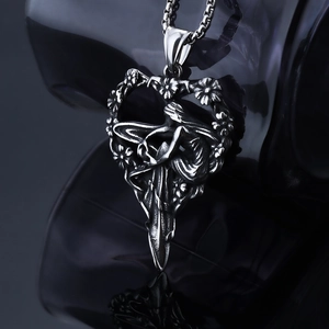Close-up of vintage silver heart pendant featuring intricate floral embossed relief and link chain
