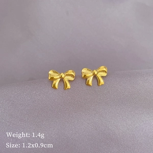 Minimalist golden titanium steel bow knot stud earrings on purple satin background