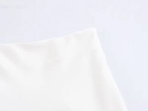 Nahaufnahme der weißen 3D-Blumenkleid-Stoffstruktur und elegantem Saumdetail