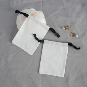 Vue détaillée de deux petites pochettes en coton blanc avec cordon pour bijoux