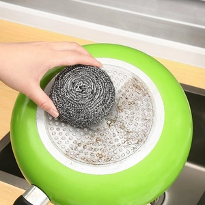 Durable stainless steel scrubbing ball effectively removing stubborn stains from cookware